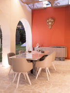 Vesper dining set — marble table, bucket chairs and sideboard, courtyard setting