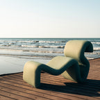 Swale Chair seen from the side, showing the curve from the floor up into the seat and over into the rolled back.